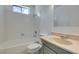 Bright bathroom with white tiled tub and shower, toilet, and cream-colored vanity at 2116 Cameron St, Las Vegas, NV 89102
