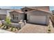 Charming single-Gathering home with a brick driveway, two-car garage, and desert landscaping at 2194 Pigeon Hawk St, Las Vegas, NV 89138