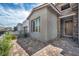 Close up of the home's entrance features with a stone entryway, modern front door, and low-maintenance landscaping at 2194 Pigeon Hawk St, Las Vegas, NV 89138