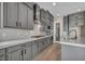 Modern kitchen featuring sleek gray cabinets, stainless appliances, cooktop and quartz countertops at 2194 Pigeon Hawk St, Las Vegas, NV 89138