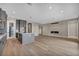 Open concept kitchen flowing to living room with gray island, hardwood floors, and modern fireplace at 2194 Pigeon Hawk St, Las Vegas, NV 89138