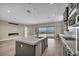 Modern kitchen with island, stainless steel appliances, fireplace and sliding glass doors leading to outdoor patio at 2194 Pigeon Hawk St, Las Vegas, NV 89138