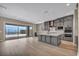 Modern gray kitchen with a central island, stainless appliances, and a sliding door to a patio at 2194 Pigeon Hawk St, Las Vegas, NV 89138