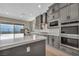 Gray kitchen with stainless appliances, double oven, kitchen island, and sliding glass doors with a view at 2194 Pigeon Hawk St, Las Vegas, NV 89138