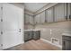 Laundry room featuring gray cabinets, white countertops, sink and tile flooring at 2194 Pigeon Hawk St, Las Vegas, NV 89138
