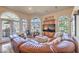 Bright living room features large leather sofa and arched windows with backyard views at 2201 Country Cottage Ct, Las Vegas, NV 89117