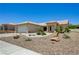 View of the desert landscaped front yard with the tile roof and tan exterior of the house at 2545 Banora Point Dr, Las Vegas, NV 89134