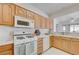 Traditional kitchen boasts natural wood cabinets, white appliances, and bright, airy atmosphere at 2545 Banora Point Dr, Las Vegas, NV 89134