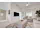 Bright living room with a high ceiling, plush carpet, and a large television at 2545 Banora Point Dr, Las Vegas, NV 89134