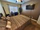A cozy bedroom features a bed with decorative pillows, a ceiling fan, and a flat screen television at 2691 Benton Cove St, Laughlin, NV 89029
