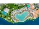 Overhead view of a community pool area with lounge chairs, a splash pad, and mature trees next to a large lake at 3150 Soft Breezes Dr # 1040, Las Vegas, NV 89128