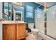 Bathroom featuring a shower with glass door, single sink vanity, and blue accent wall at 3220 W Hammer Ln, North Las Vegas, NV 89031