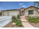 Exterior of a single-story home with desert landscaping, a two-car garage, and a tiled roof at 3220 W Hammer Ln, North Las Vegas, NV 89031