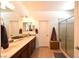 Well-lit bathroom with double sink vanity, decorative mirrors, and separate shower stall and water closet at 3621 Jasmine Heights Ave, North Las Vegas, NV 89081