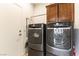 Functional laundry room with side-by-side washer and dryer and storage cabinetry at 3621 Jasmine Heights Ave, North Las Vegas, NV 89081