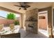 Covered patio with a stone fireplace, ceiling fan, and comfortable seating at 3621 Jasmine Heights Ave, North Las Vegas, NV 89081