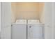 This laundry room features a white washer and dryer as well as a shelf and shuttered door at 3961 Bayamon St, Las Vegas, NV 89129