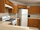 Functional kitchen with gas range, matching white refrigerator and microwave, light countertops and honey-colored wooden cabinets at 4113 Arcola Ave, Las Vegas, NV 89110