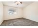 Cozy bedroom with neutral carpet, a ceiling fan, and a bright window at 4611 Four Leaf Clover Dr, Las Vegas, NV 89122