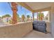 Outdoor patio features a BBQ grill for cooking and views of palm trees and nearby apartment buildings at 5012 Newport Cove Dr # C, Las Vegas, NV 89119