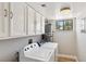 Functional laundry room with modern washer and dryer, white cabinets, and good natural light at 5063 Eldora Ave # 4, Las Vegas, NV 89146
