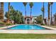 Community pool with palm trees, grass area, and residential buildings in the background at 5063 Eldora Ave # 4, Las Vegas, NV 89146