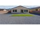 Open gravel backyard featuring a newly installed artificial lawn and glass door to the home at 5357 Eleganza Ave, Pahrump, NV 89061