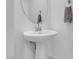 Half bathroom featuring a pedestal sink, round mirror, and towel racks at 5357 Eleganza Ave, Pahrump, NV 89061