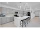 Beautiful kitchen with a large quartz island, pendant lights, grey cabinets, and stainless steel appliances at 5357 Eleganza Ave, Pahrump, NV 89061