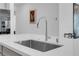 Close-up of a kitchen island with stainless steel sink, modern faucet and quartz countertop at 5357 Eleganza Ave, Pahrump, NV 89061