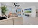 Bright living room with a comfortable sofa, large windows, and a modern ceiling fan, creating an inviting atmosphere at 5357 Eleganza Ave, Pahrump, NV 89061