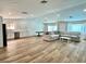 Open-concept living area with wood floors, recessed lights, and a modern kitchen in the background at 6191 Bullion Blvd, Las Vegas, NV 89103