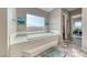 Bright bathroom featuring a large soaking tub, tiled floor, and adjacent rooms at 6311 Baker Creek St, Las Vegas, NV 89149