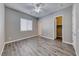 A bright, open bedroom with gray laminate flooring, and neutral colored walls at 6311 Baker Creek St, Las Vegas, NV 89149