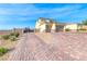 Two-story stucco home with a two-car garage and brick driveway and gated RV parking at 6311 Baker Creek St, Las Vegas, NV 89149