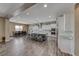 Open kitchen and dining area with large island, stainless appliances, and stylish wood flooring at 6311 Baker Creek St, Las Vegas, NV 89149