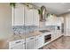 Modern kitchen features white cabinets, stainless steel appliances, and patterned backsplash at 6311 Baker Creek St, Las Vegas, NV 89149