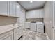 Well-organized laundry room with white cabinets, sink, washer, and dryer at 6311 Baker Creek St, Las Vegas, NV 89149
