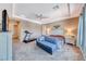 Spacious bedroom features a tray ceiling, plush carpeting, and a cozy seating area at 6311 Baker Creek St, Las Vegas, NV 89149