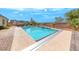 Backyard featuring a pristine pool, desert landscaping, and a pergola with outdoor dining furniture at 6311 Baker Creek St, Las Vegas, NV 89149