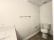 Bathroom features toilet, towel bar, and marble-topped vanity with white cabinets at 6638 Babys Tear Pl, Las Vegas, NV 89148