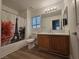 This bathroom features a shower-tub combo, a vanity with a marble countertop, and wood-look flooring at 6638 Babys Tear Pl, Las Vegas, NV 89148