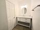 Bathroom with single marble vanity, round mirror, and white shaker cabinets at 6638 Babys Tear Pl, Las Vegas, NV 89148