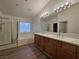A bathroom with double sinks, and a glass door shower, with a tub under the window at 6638 Babys Tear Pl, Las Vegas, NV 89148
