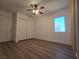 Comfortable bedroom with wood-look floors, sliding door closet, and a window for natural light at 6638 Babys Tear Pl, Las Vegas, NV 89148