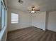 This bedroom features wood-look flooring, a ceiling fan, and a double door closet at 6638 Babys Tear Pl, Las Vegas, NV 89148