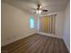 Cozy bedroom featuring wood-look floors, ceiling fan, and a window with two-toned accent curtains at 6638 Babys Tear Pl, Las Vegas, NV 89148