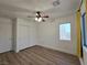 This bedroom features wood-look flooring, a ceiling fan, and a double door closet at 6638 Babys Tear Pl, Las Vegas, NV 89148