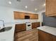 Well-lit kitchen features a peninsula, wood cabinets, light countertops, and modern appliances at 6638 Babys Tear Pl, Las Vegas, NV 89148