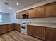 Bright kitchen features wood cabinets, light countertops, white appliances, and wood flooring at 6638 Babys Tear Pl, Las Vegas, NV 89148